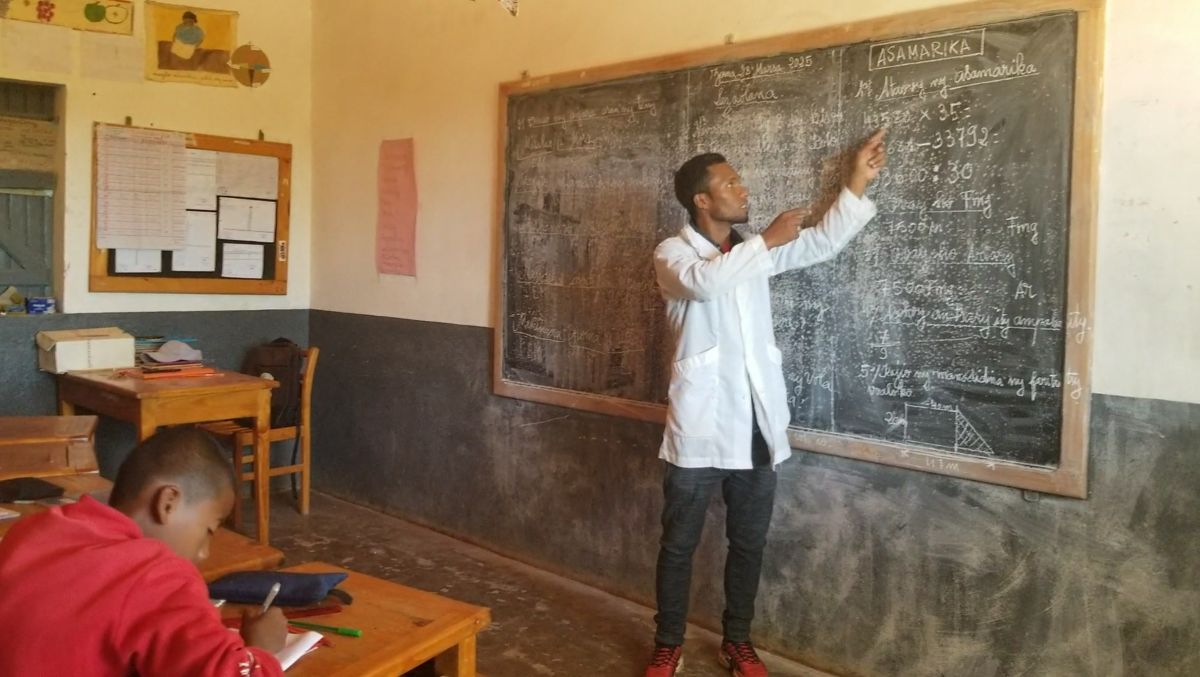 a teacher points to numbers on a chalkboard
