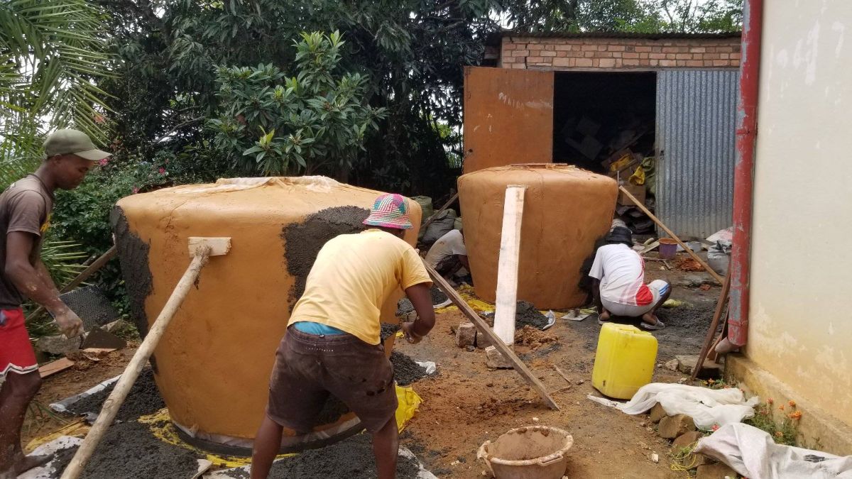 a group of men working on large water jugs