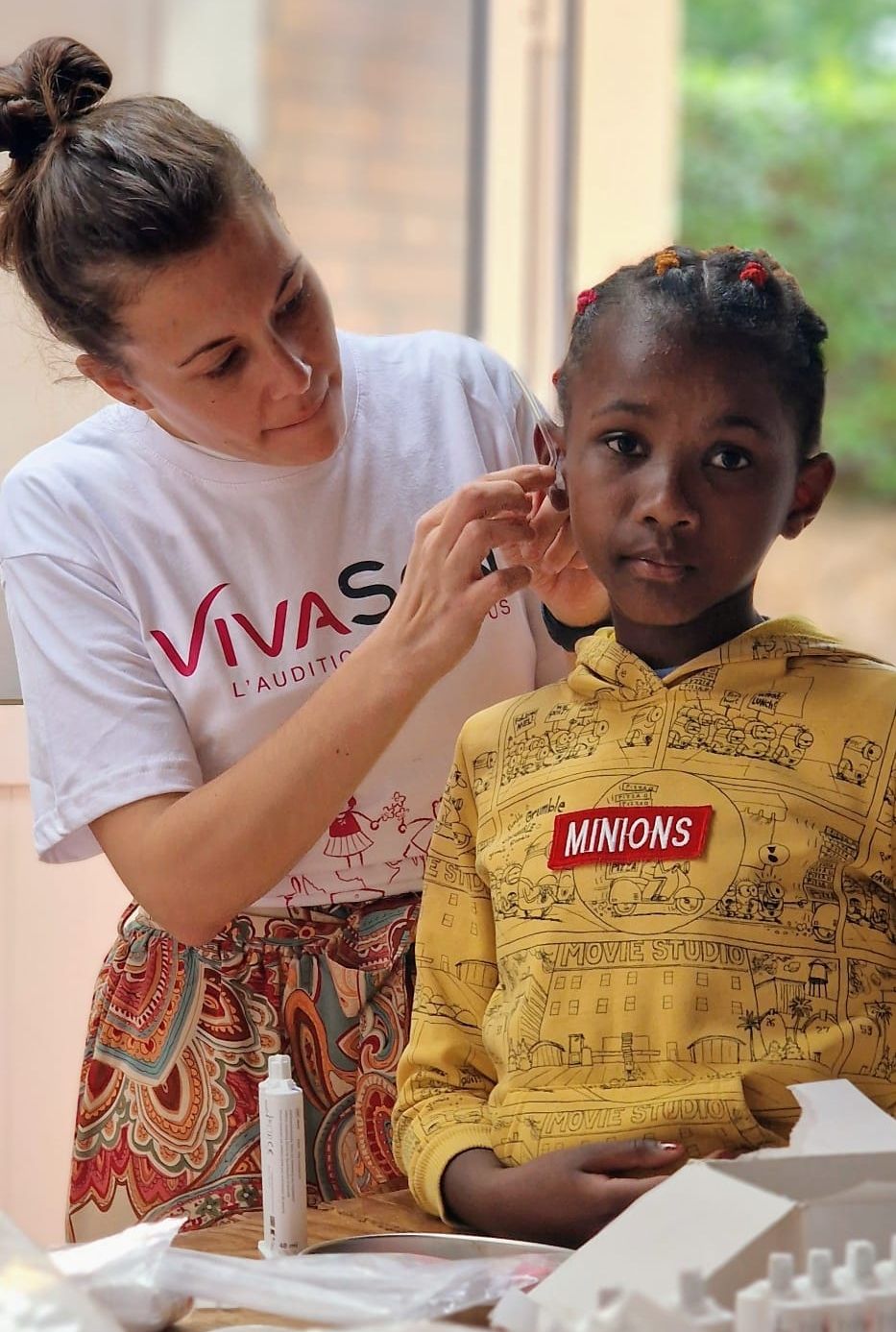 Aro is fitted for a hearing aid by a volunteer