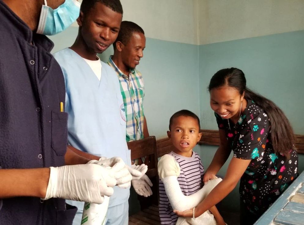 Adults surround a 10-year-old boy at the hospital in Fianarantsoa after helping to put a cast on his broken arm.