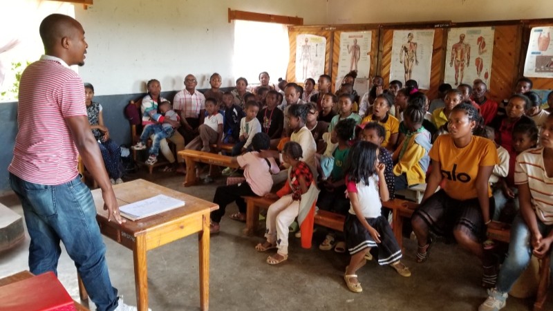 Members of the SEMAFI community listen as a dentist speaks to them.